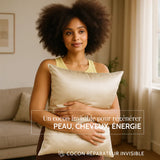 Femme afro-descendante tenant une taie d’oreiller en soie couleur champagne, dans un intérieur lumineux. Texte “Un cocon invisible pour régénérer peau, cheveux, énergie”.