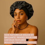 Femme portant le bonnet en soie noir SilkDream™, lumière chaude et regard confiant