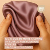 Zoom sur une main tenant la soie de mûrier 19 momme, texture brillante et souple, label OEKO-TEX® visible